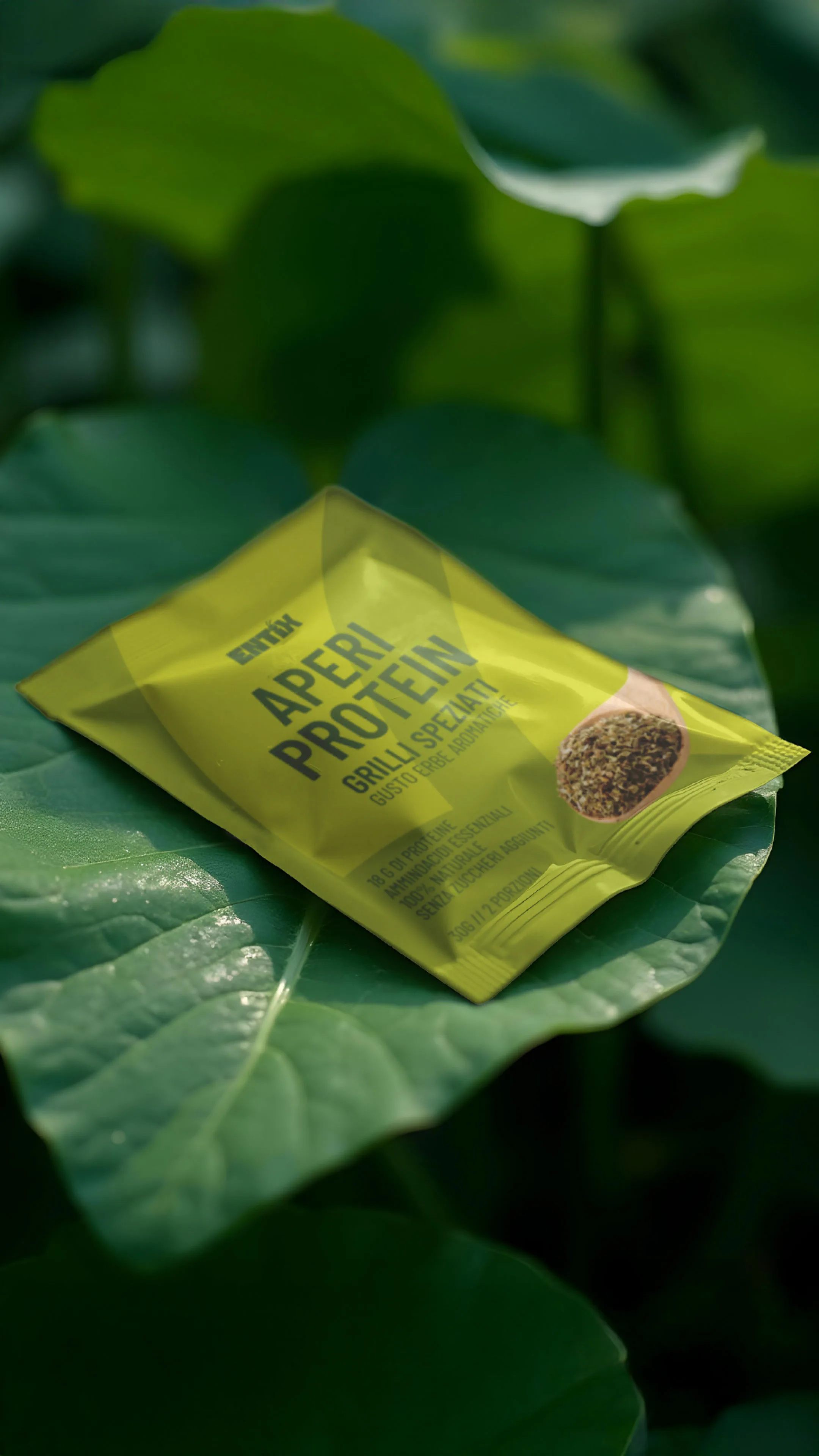 Bustina di snack proteico Entix ai grilli speziati, su una foglia verde.