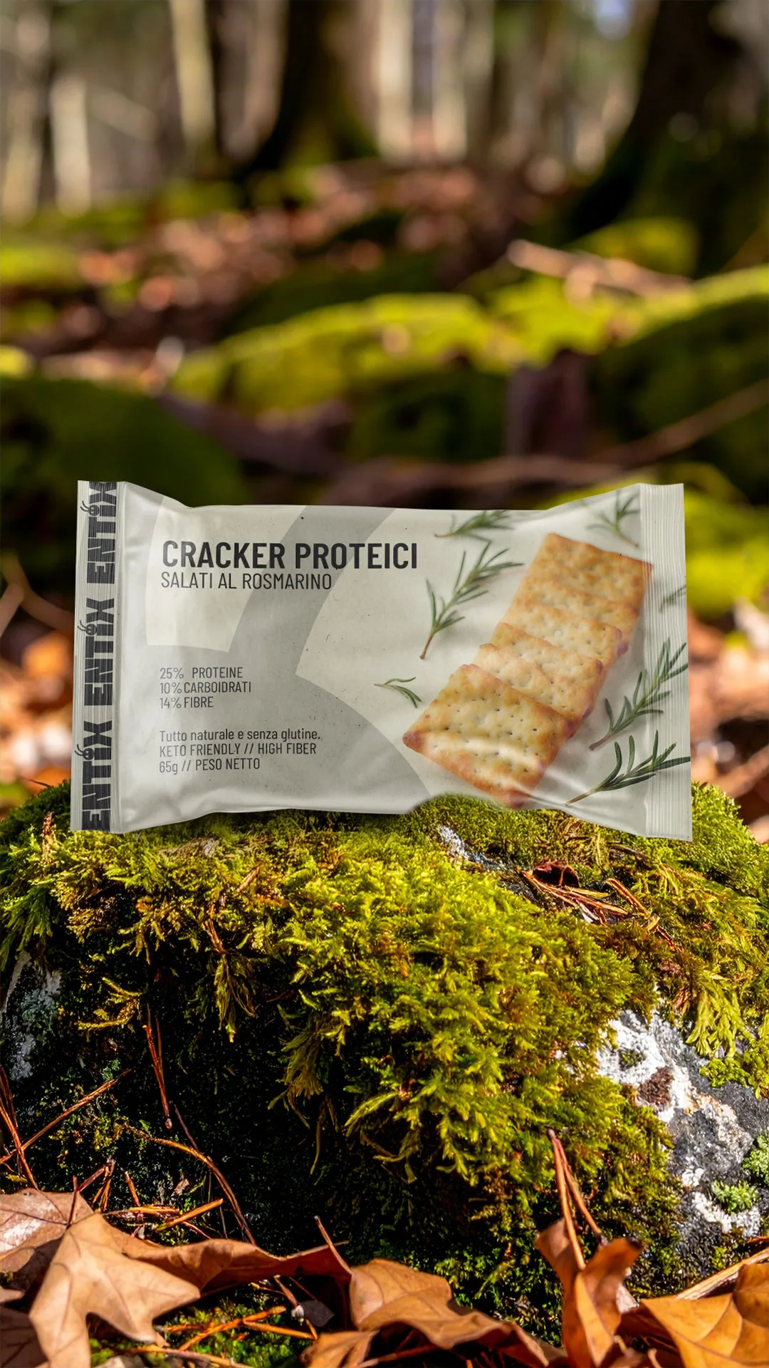 Confezione di cracker proteici Entix al rosmarino, su un masso muschiato nel bosco.