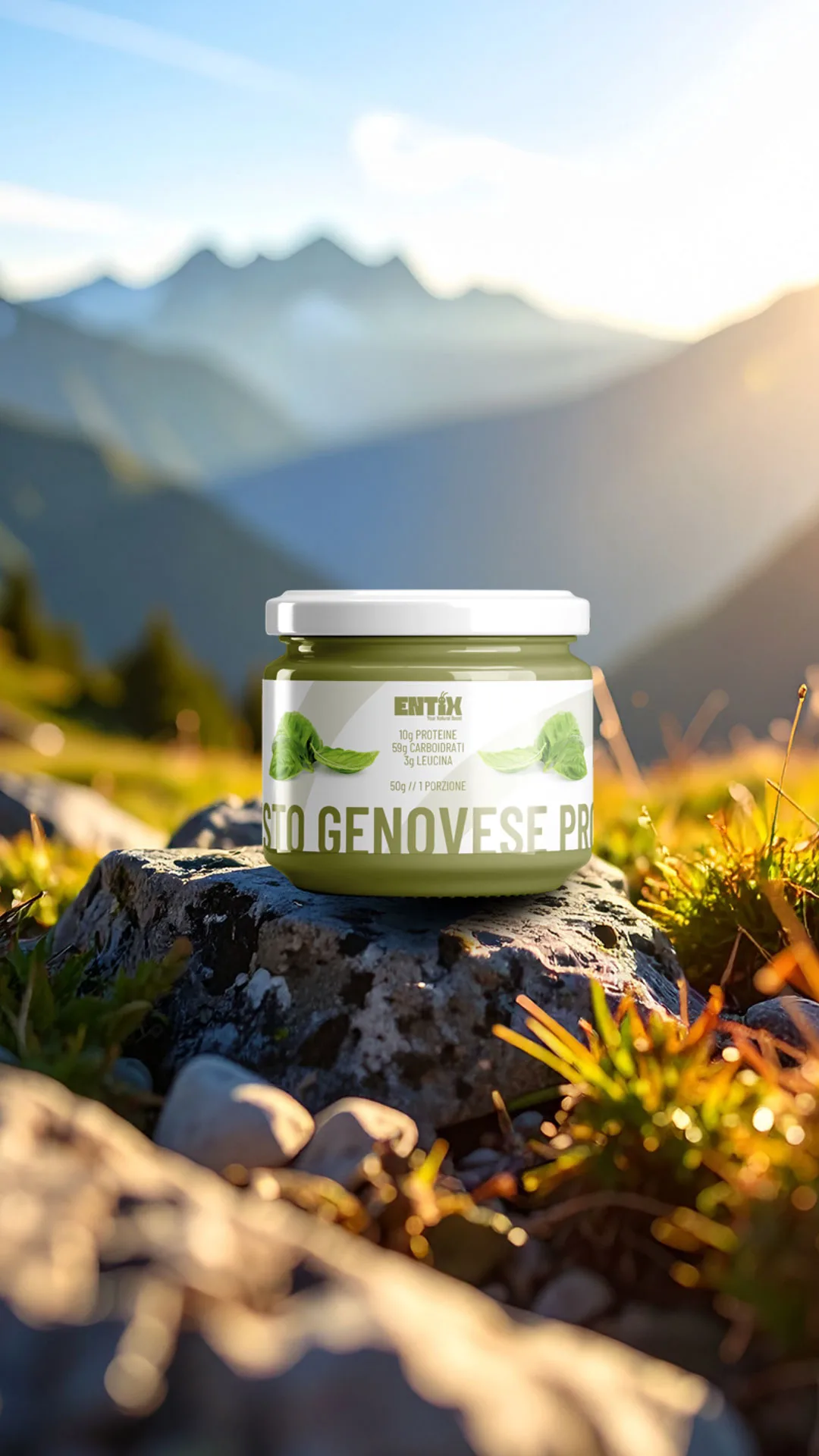 Vasetto di pesto genovese proteico Entix su una roccia, montagne sullo sfondo.