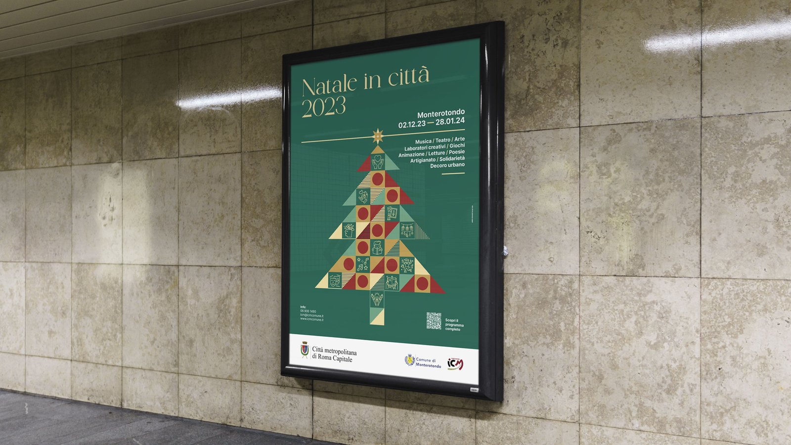 Manifesto in una bacheca illuminata su un muro di travertino: fondo verde, titolo Natale in città 2023 in oro, un albero di Natale composto da triangoli e quadrati verdi, rossi e oro con dentro delle icone, e la riga Monterotondo 02.12.23 — 28.01.24.
