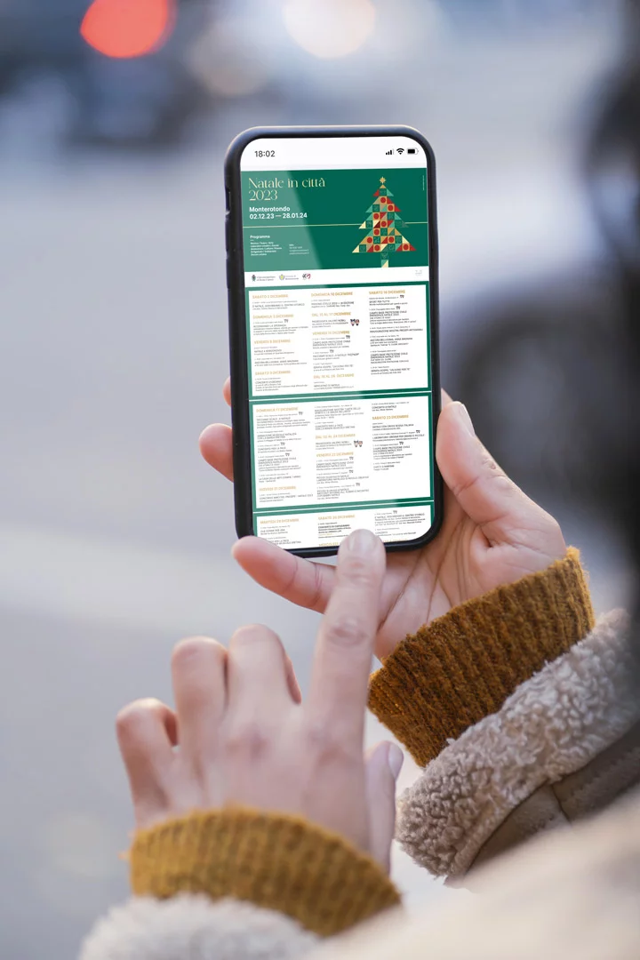 Telefono tenuto in verticale per strada: sotto la testata verde scorre il calendario completo, diviso in riquadri per giorno con gli orari e i luoghi degli appuntamenti.