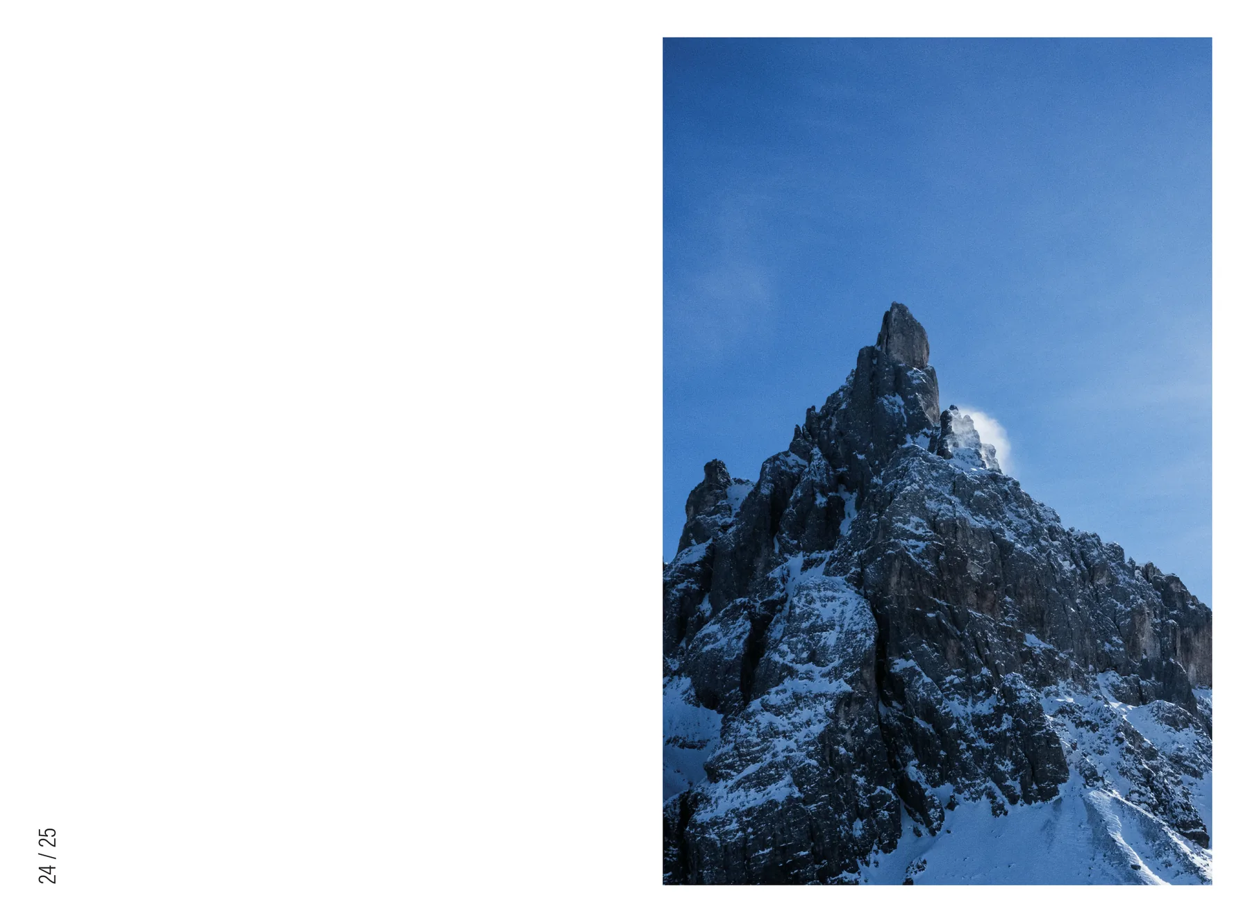 Doppia pagina quasi tutta bianca: a destra, in verticale, la guglia del Cimon della Pala contro un cielo blu profondo.